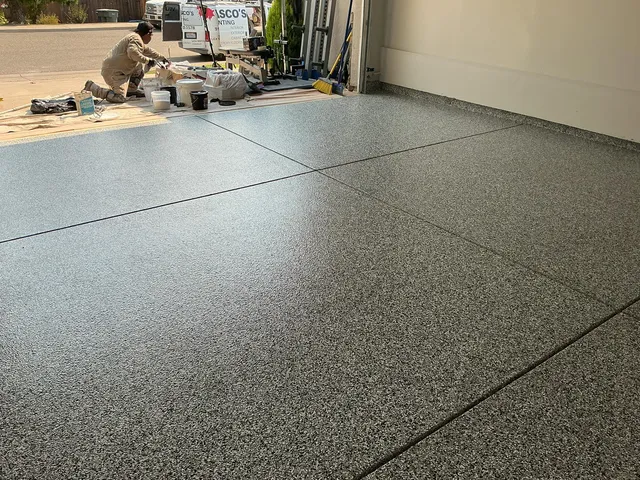 Gray flake epoxy garage floor at driveway edge