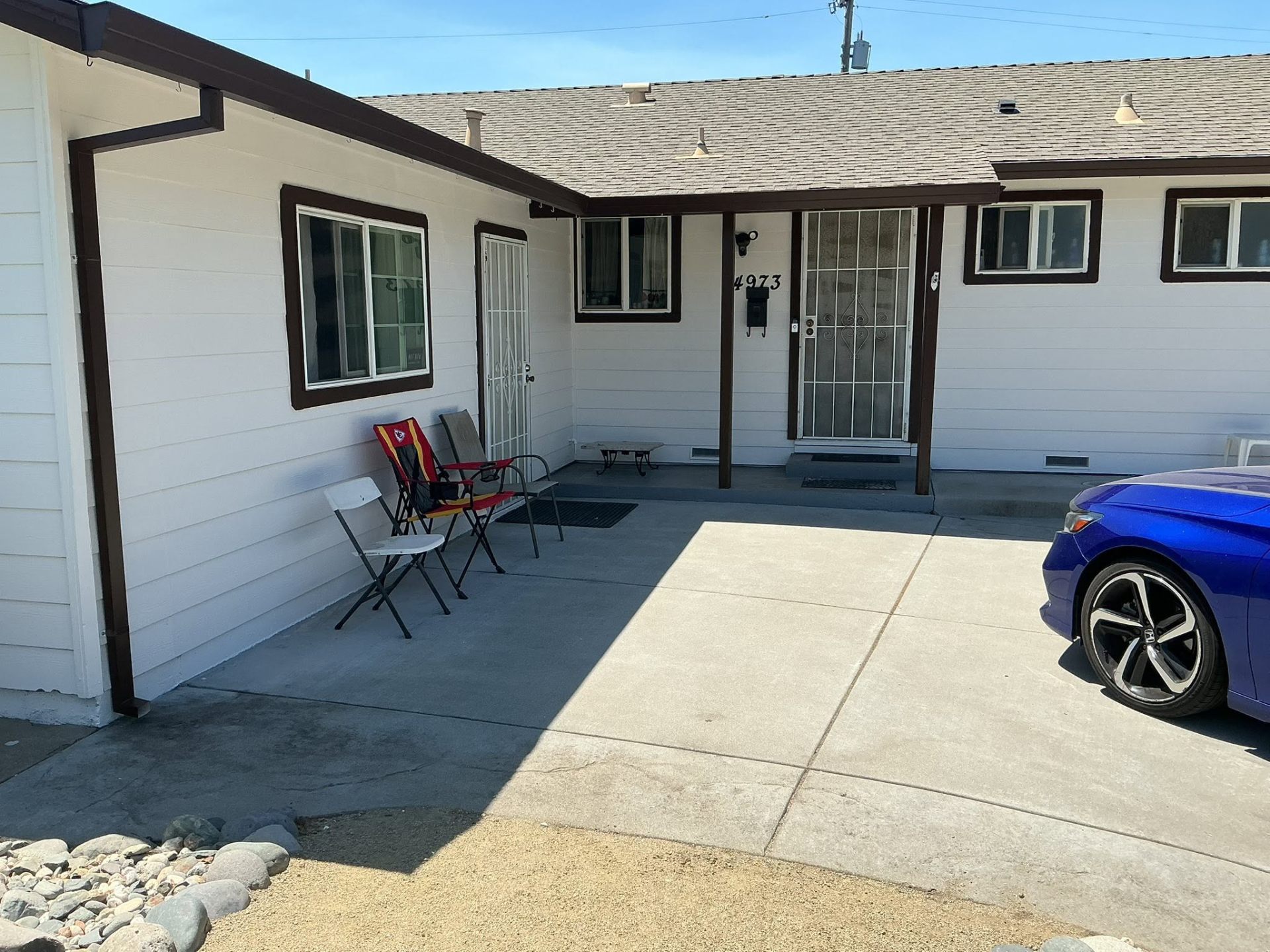 Ranch home entry porch with newly painted brown posts and white siding