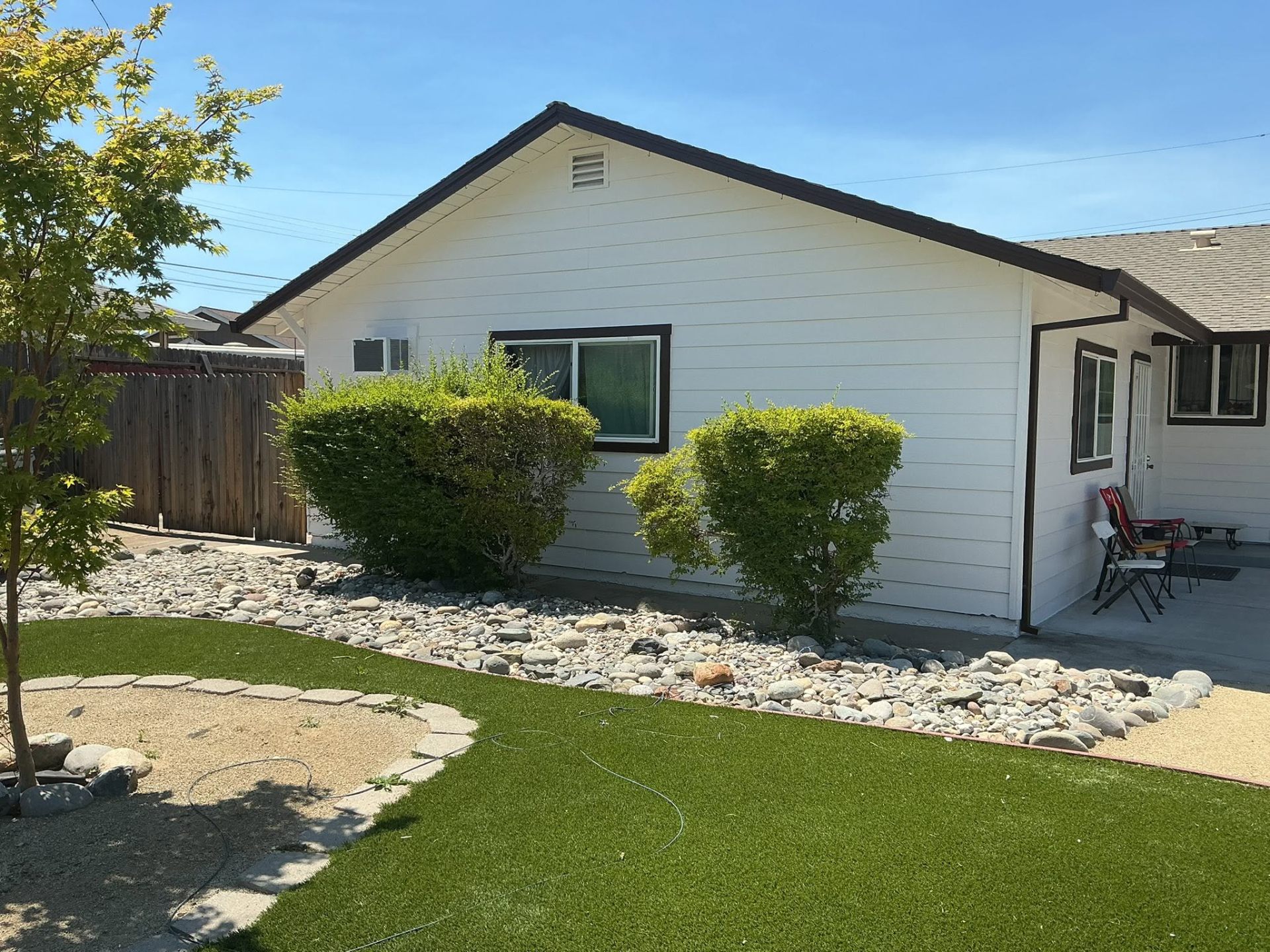 Ranch home side elevation with fresh white siding and brown eaves