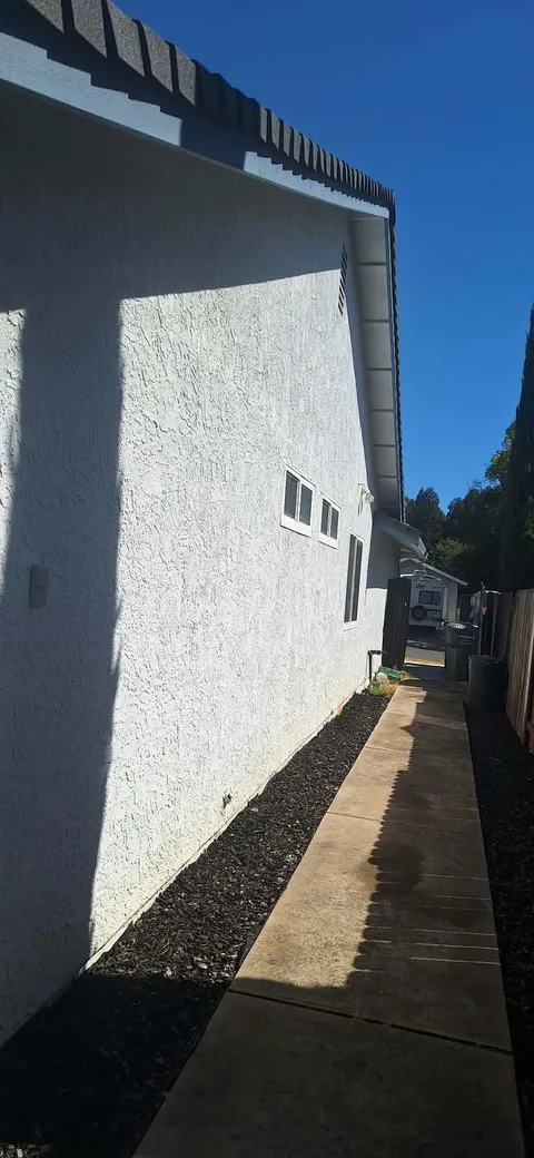 Clean white stucco wall along a side walkway