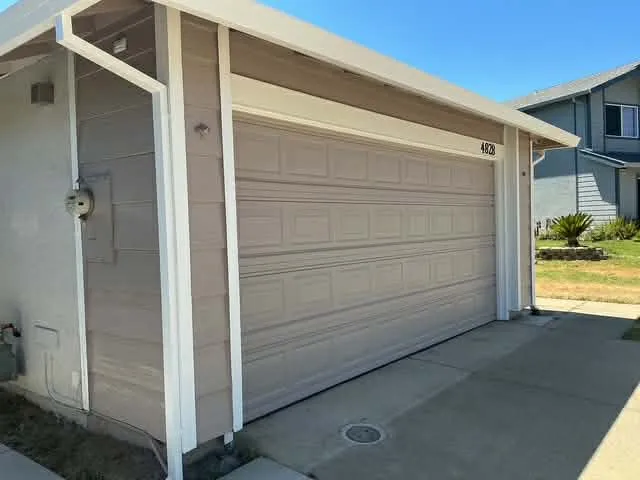 Repainted tan garage door with white trim accents