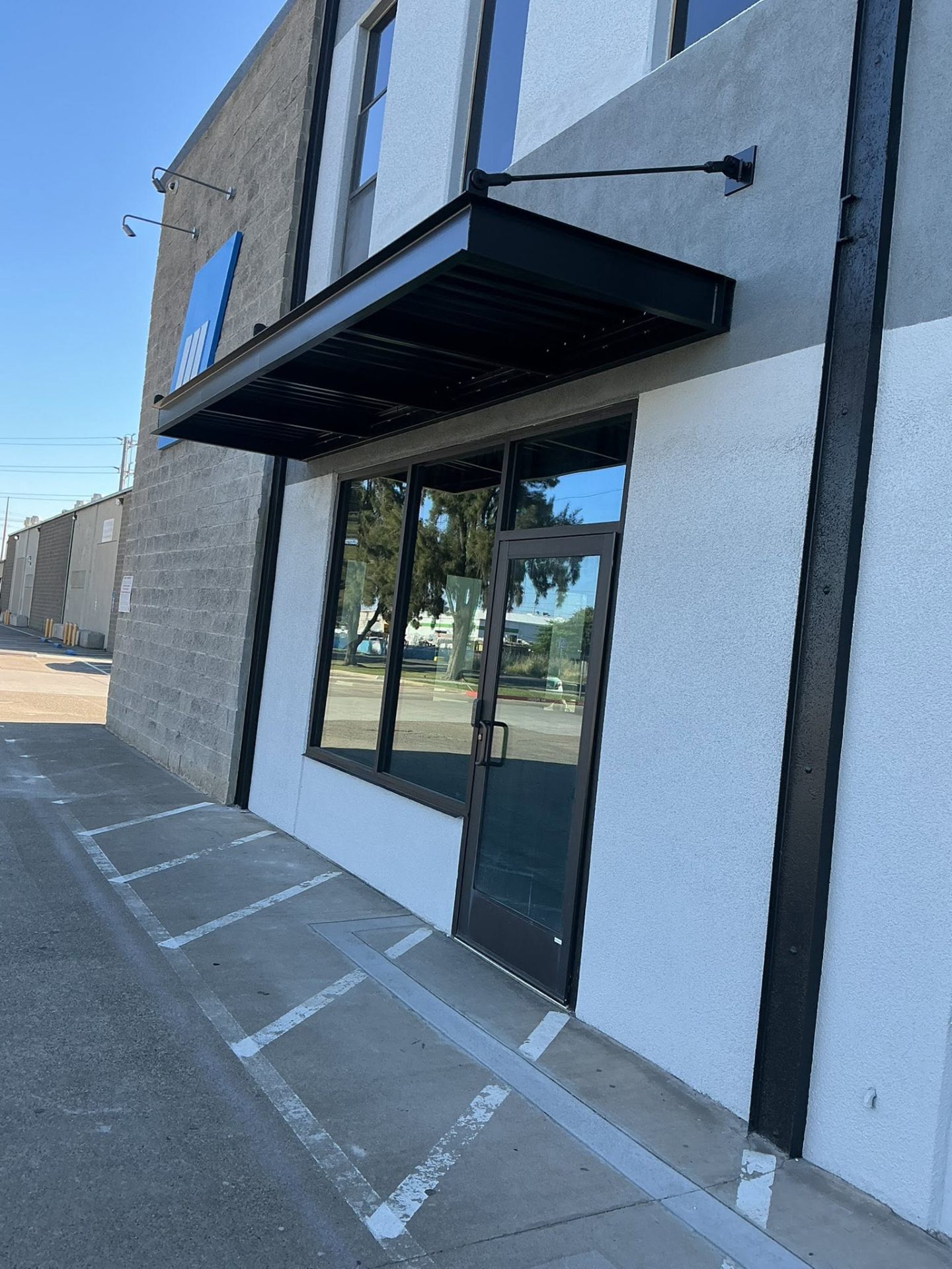 Commercial storefront repaint with black metal awning and stone accents