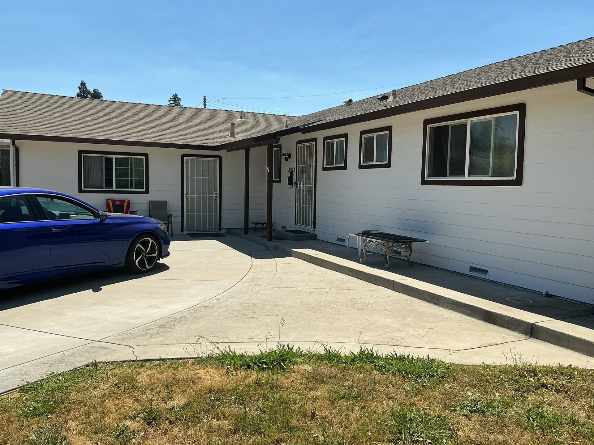 White ranch home repaint with warm brown fascia and trim