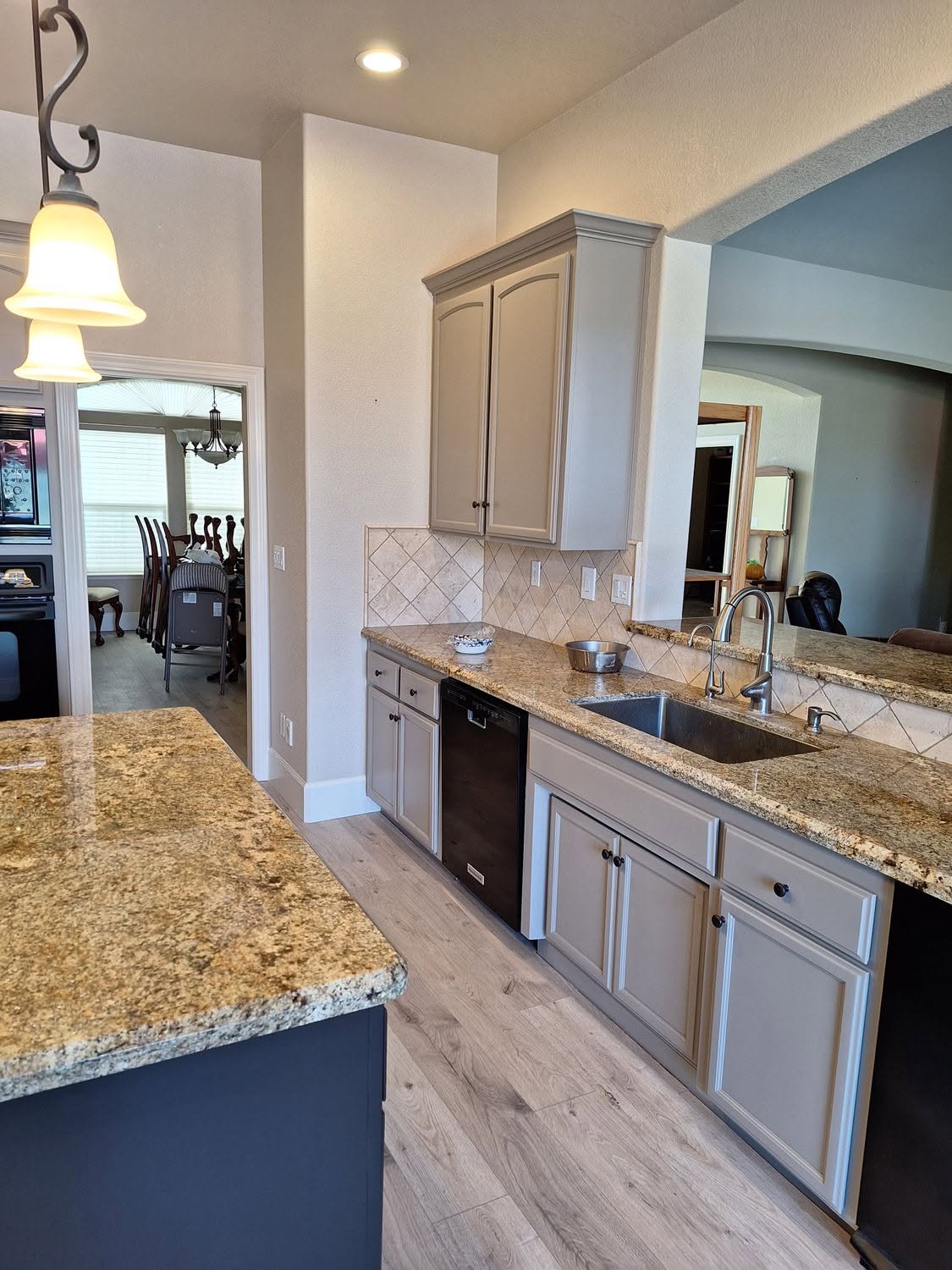 Taupe refinished cabinets with a deep navy island